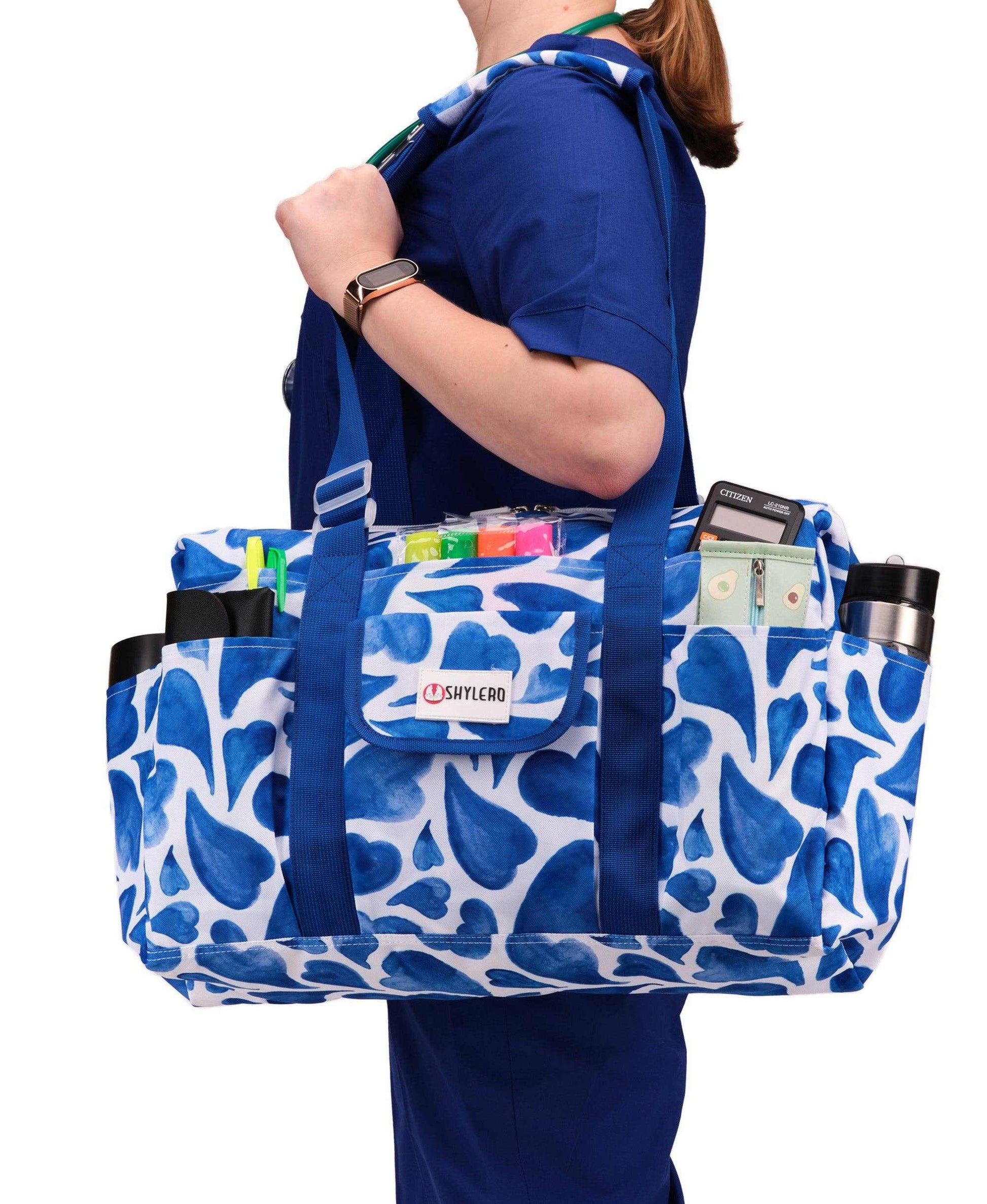 Nurse Bag and Utility Tote | Waterproof | Blue HeartsGrab Your Large SHYLERO Utility Bag and Enjoy: 

 * 14 OUTSIDE POCKETS 
 * 7 INSIDE POCKETS 
 * DEDICATED LAPTOP COMPARTMENT (UP TO 17") 
 * LARGE &amp; ROOMY - sizetoteNurse BagSHYLEROScrub Angel & Accessories 